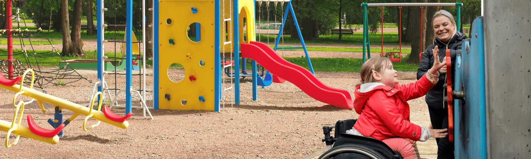 IMAGE: A Young child who uses a wheelchair is in the park with their keyworker