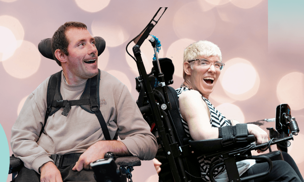 IMAGE DESCRIPTION: Two clients who use a motorised wheelchair are smiling to camera