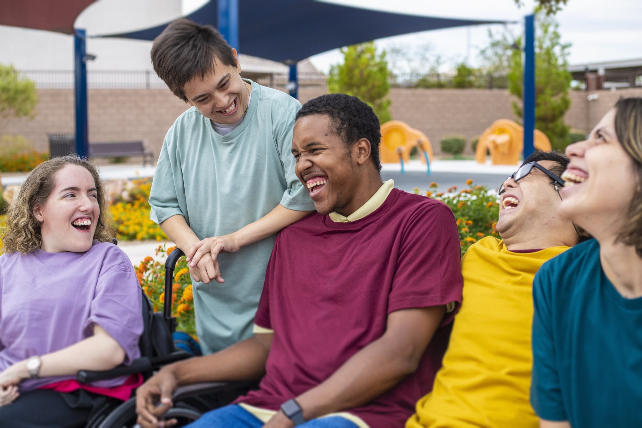 IMAGE: friends are hanging out together in a park area, they are laughing and chatting