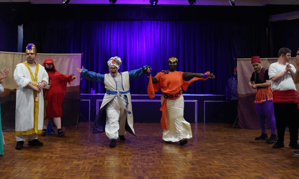 Clients playing aladdin and jasmine take their bow infront of the audience