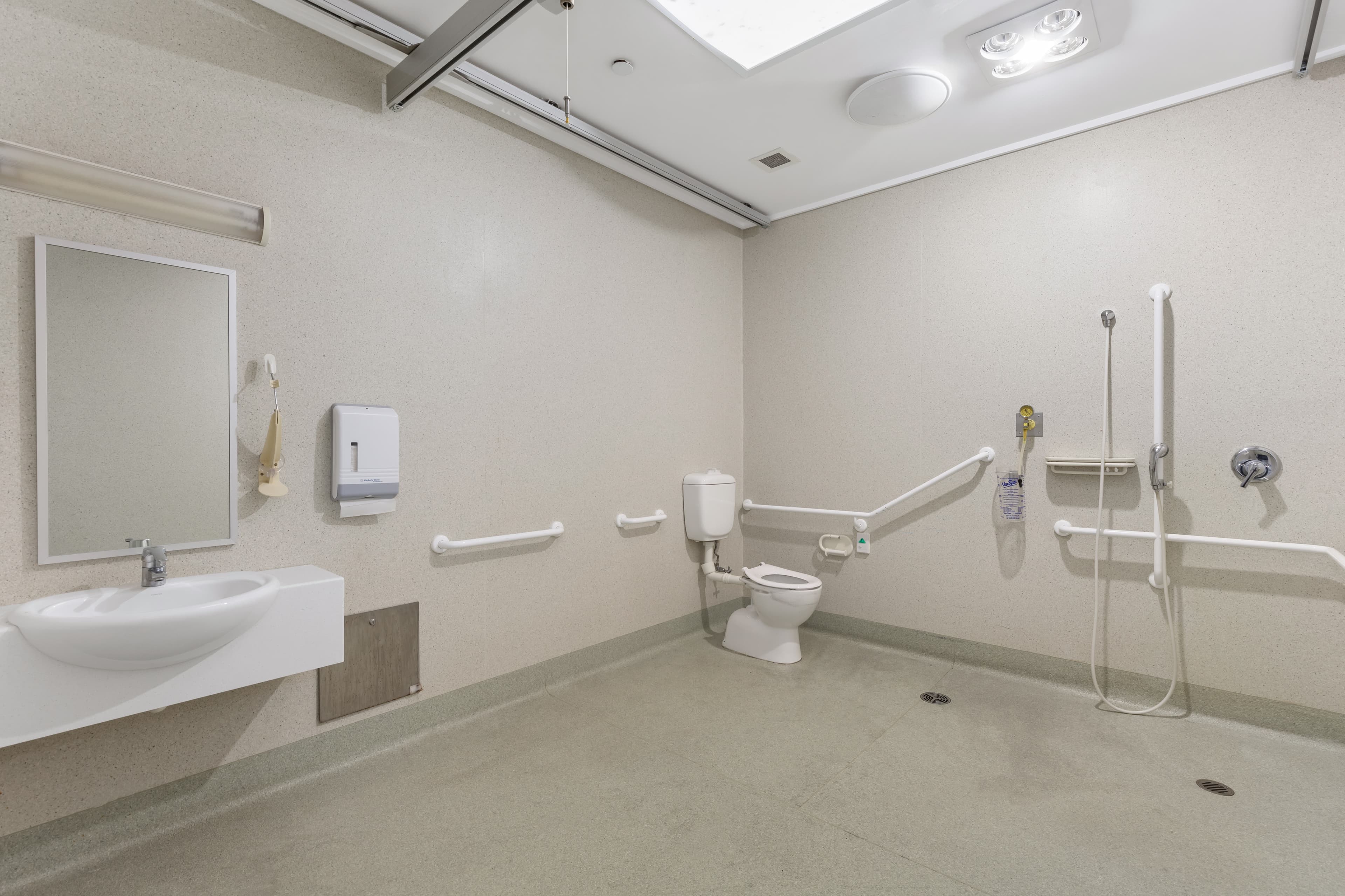 Image: Bathroom with a toilet, handheld shower and a basin