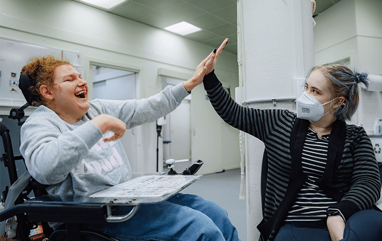 Image: Yooralla client and Yooralla Disability Support worker high-five