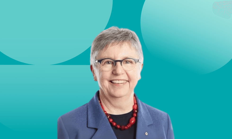 An image of doctor Jo Flynn wearing a colourful red necklace and glasses smiling to camera